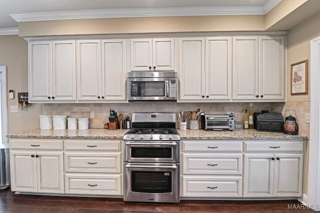 kitchen featuring dark wood-type flooring, ornamental molding, white cabinets, stainless steel appliances, and backsplash