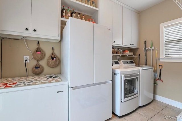 laundry area featuring cabinets, light tile patterned floors, and independent washer and dryer