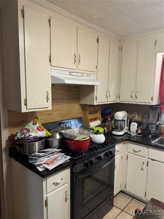 kitchen with black range with gas cooktop, light tile patterned floors, a textured ceiling, and white cabinets