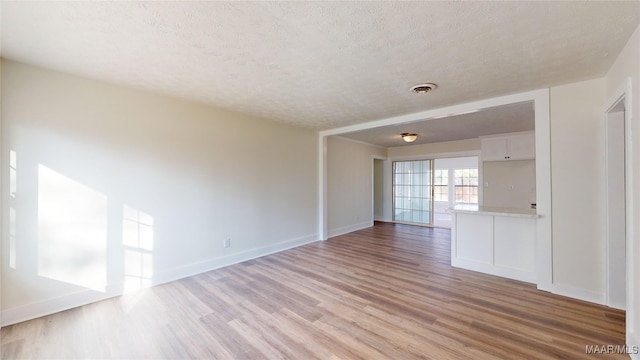 empty room featuring a textured ceiling and light wood-type flooring