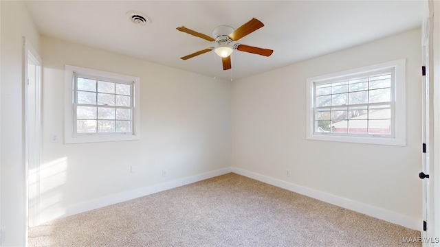 carpeted empty room with a healthy amount of sunlight and ceiling fan