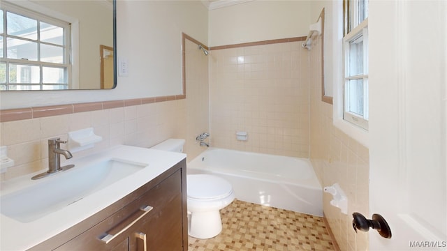 full bathroom with tiled shower / bath combo, vanity, tile walls, and toilet