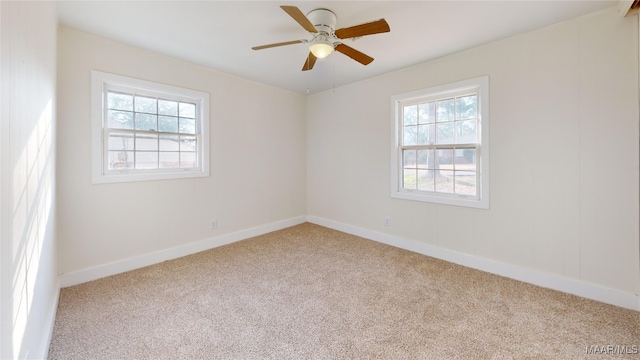 carpeted empty room featuring ceiling fan and a wealth of natural light