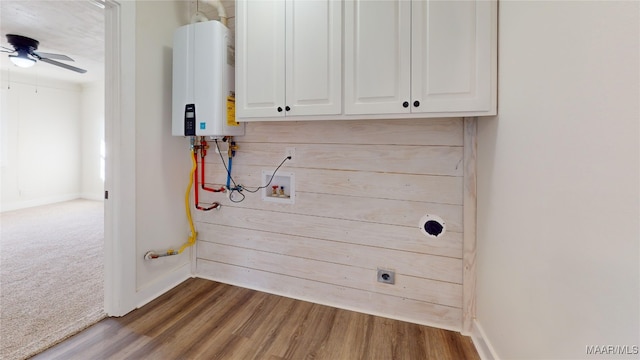 laundry room with water heater, electric dryer hookup, hardwood / wood-style floors, hookup for a washing machine, and cabinets