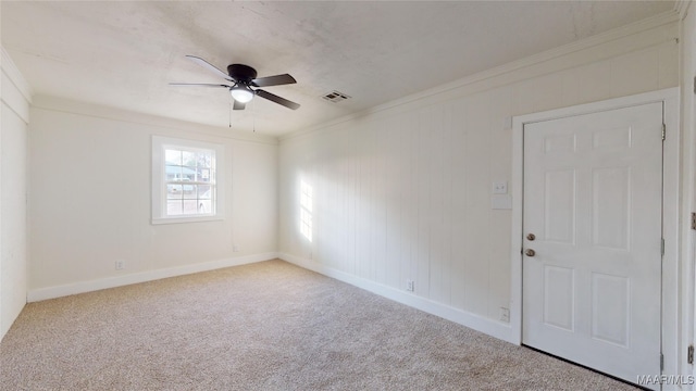 carpeted spare room featuring ceiling fan and ornamental molding