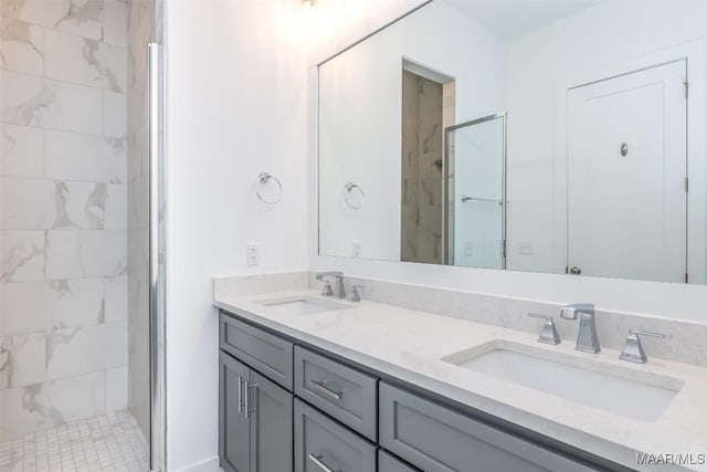 bathroom featuring a shower with door and vanity