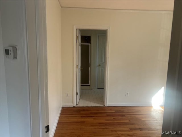 corridor with wood finished floors and baseboards