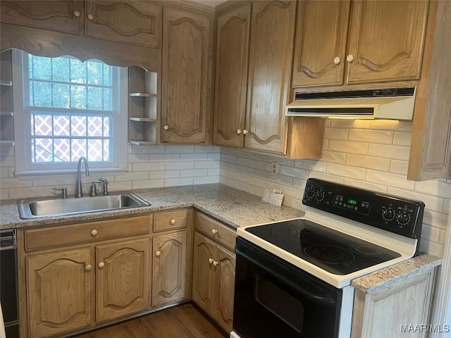 kitchen featuring under cabinet range hood, dark wood-style flooring, range with electric stovetop, a sink, and light countertops