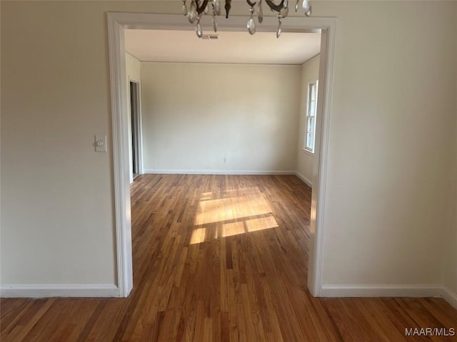 unfurnished dining area with hardwood / wood-style flooring and a chandelier