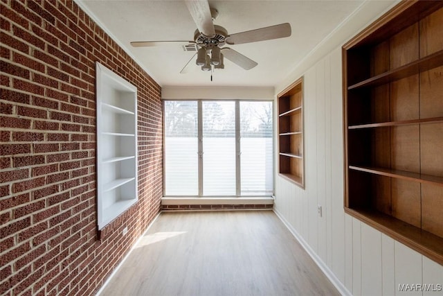 unfurnished sunroom with ceiling fan