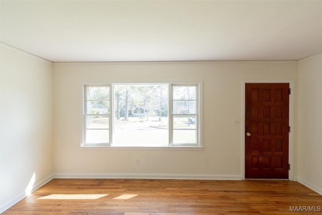 unfurnished room with light wood finished floors and baseboards