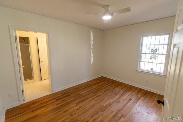 empty room with baseboards, a ceiling fan, and wood finished floors