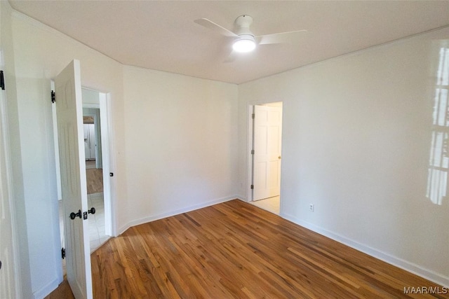 unfurnished room with baseboards, a ceiling fan, and wood finished floors