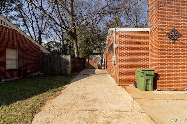 view of home's exterior with brick siding and fence