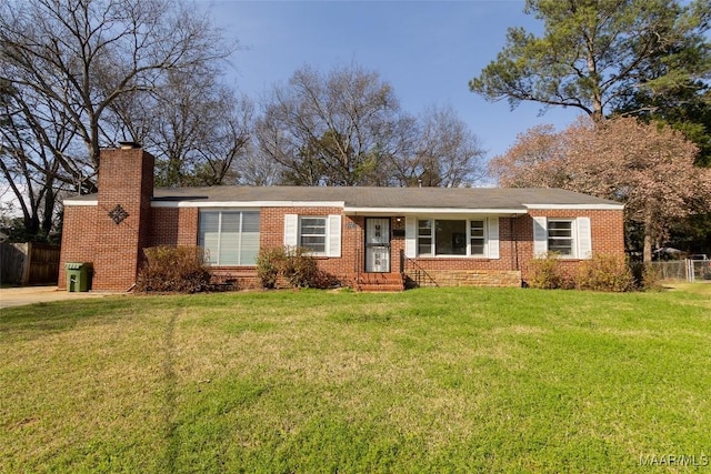 ranch-style house with brick siding, a chimney, fence, and a front yard