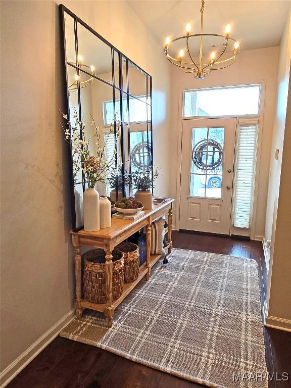 foyer featuring an inviting chandelier and dark hardwood / wood-style flooring