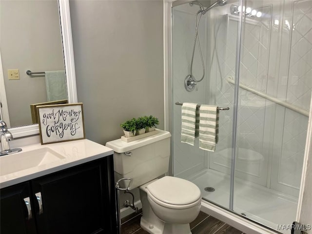 bathroom with vanity, a shower with door, and toilet