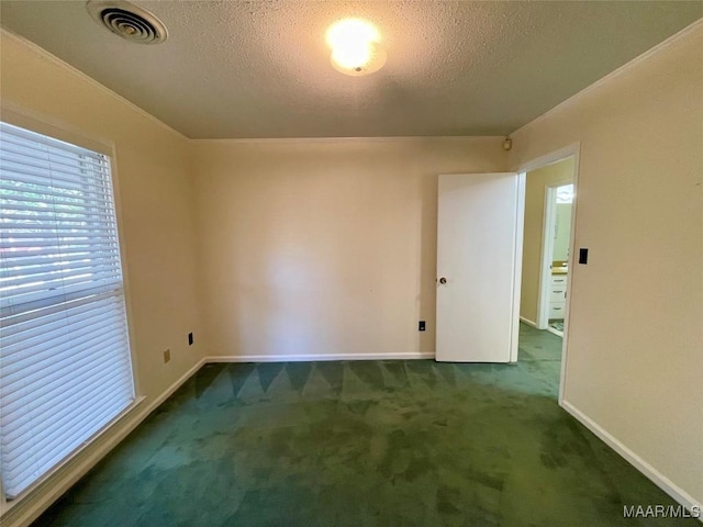 unfurnished room with a textured ceiling and dark colored carpet