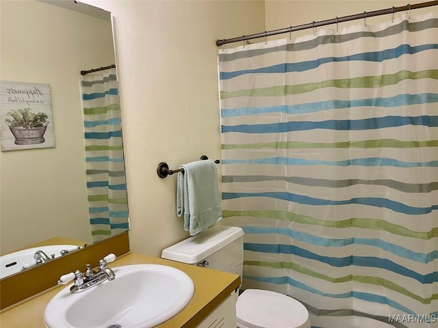 bathroom with vanity, toilet, and curtained shower