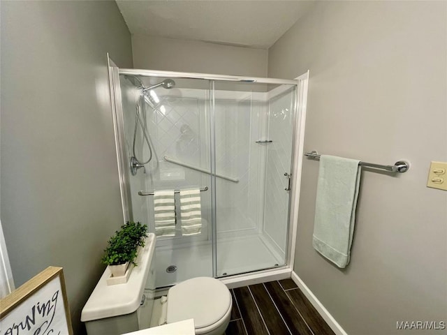 bathroom featuring an enclosed shower and toilet