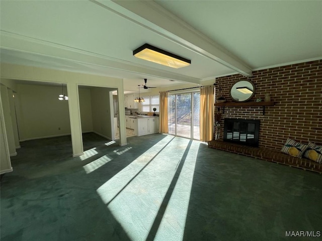 unfurnished living room with brick wall, dark colored carpet, a brick fireplace, and beam ceiling