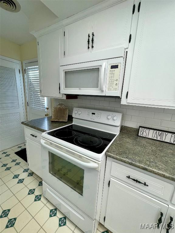 kitchen with white cabinetry, backsplash, and white appliances