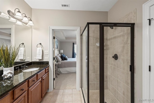 bathroom featuring a shower with door, vanity, and tile patterned floors