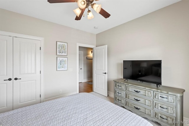 bedroom with ceiling fan, light carpet, and a closet