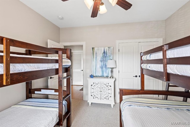 carpeted bedroom featuring ceiling fan and a closet