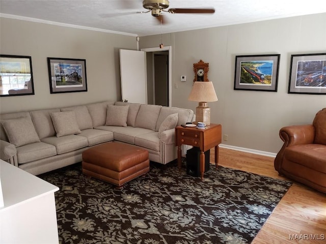 living room with hardwood / wood-style flooring, ornamental molding, and ceiling fan