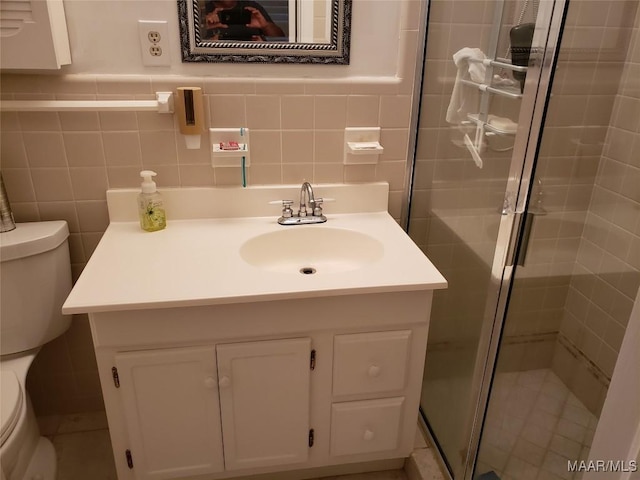 bathroom featuring vanity, tile walls, toilet, and walk in shower