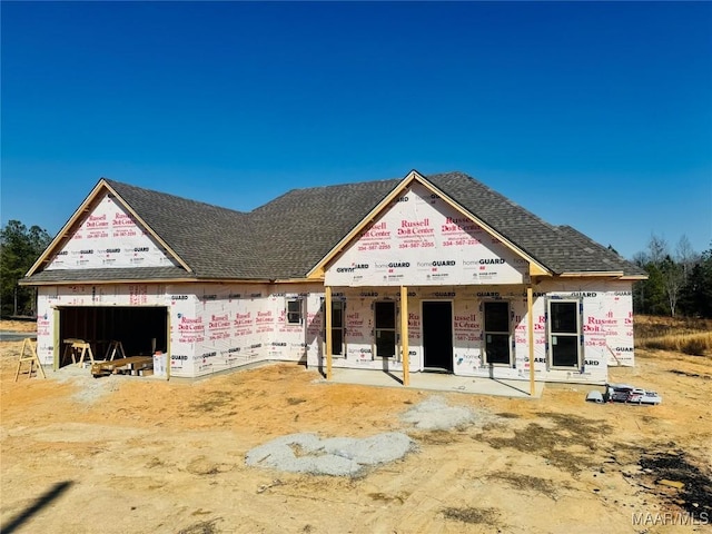 property in mid-construction with a garage and roof with shingles