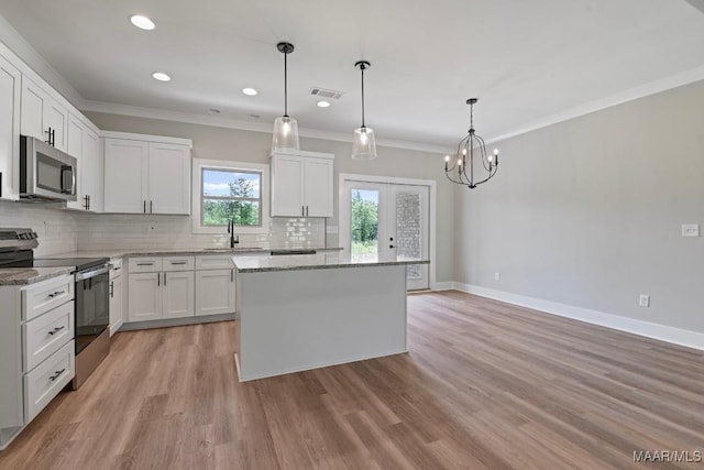 116 Madix Dr, Eclectic, AL 36024 - kitchen with stainless steel appliances, backsplash, a center island, white cabinetry, and crown molding