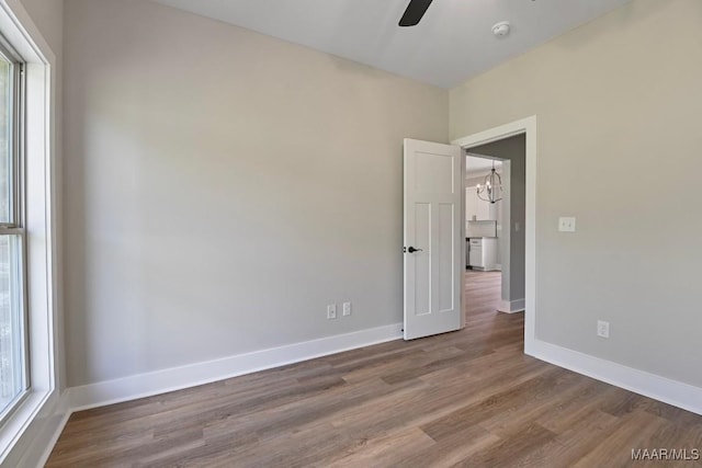 116 Madix Dr, Eclectic, AL 36024 - spare room with wood finished floors, ceiling fan, a smoke detector, and a chandelier