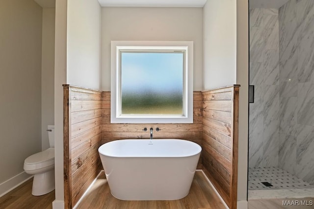 116 Madix Dr, Eclectic, AL 36024 - bathroom with wood finished floors, a stall shower, a freestanding bath, and a wainscoted wall
