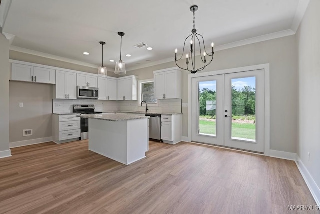 116 Madix Dr, Eclectic, AL 36024 - kitchen with appliances with stainless steel finishes, white cabinets, decorative backsplash, french doors, and ornamental molding