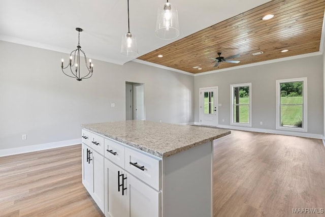 116 Madix Dr, Eclectic, AL 36024 - kitchen with light wood finished floors, a center island, light stone countertops, decorative light fixtures, and ornamental molding