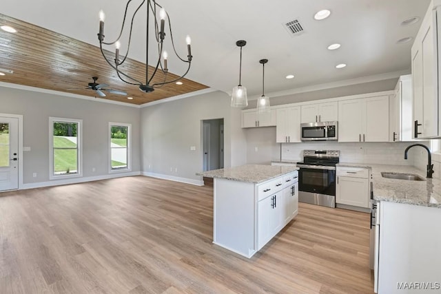 116 Madix Dr, Eclectic, AL 36024 - kitchen with stainless steel appliances, crown molding, ceiling fan, a center island, and white cabinets