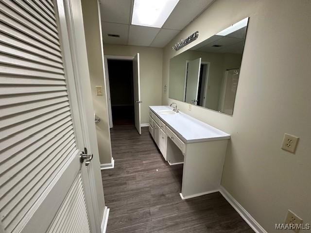 bathroom with a paneled ceiling, vanity, and hardwood / wood-style floors