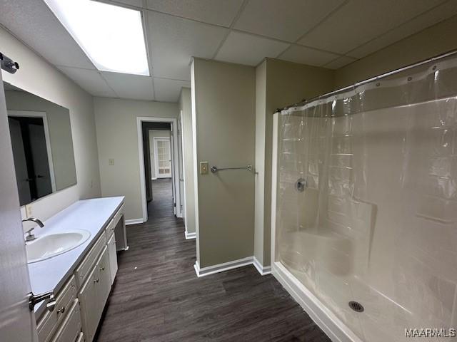 bathroom featuring hardwood / wood-style flooring, vanity, a drop ceiling, and a shower with curtain