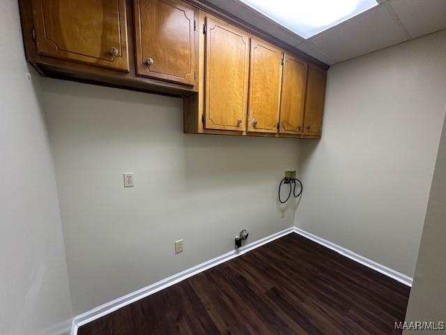 clothes washing area with hookup for a washing machine, gas dryer hookup, dark hardwood / wood-style floors, and cabinets