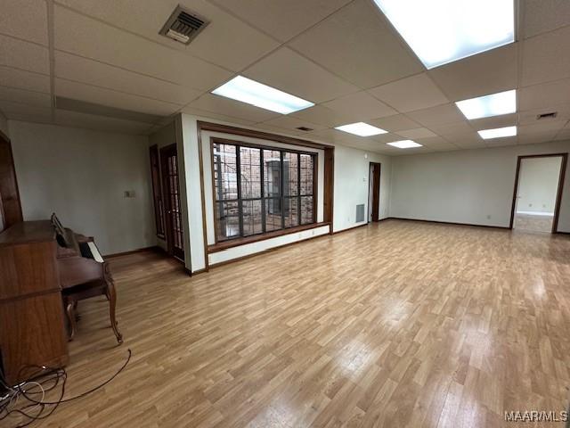 unfurnished room with hardwood / wood-style flooring and a paneled ceiling