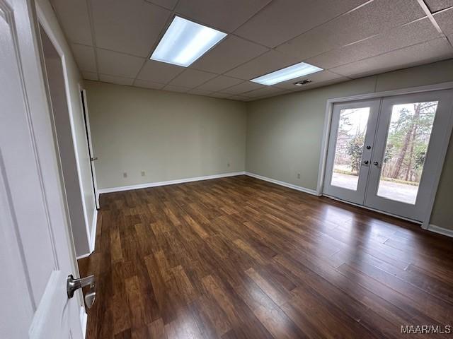 spare room with dark wood-type flooring, a paneled ceiling, and french doors