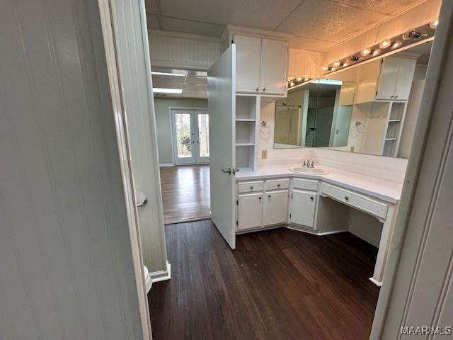 bathroom with hardwood / wood-style flooring, vanity, french doors, and wood walls