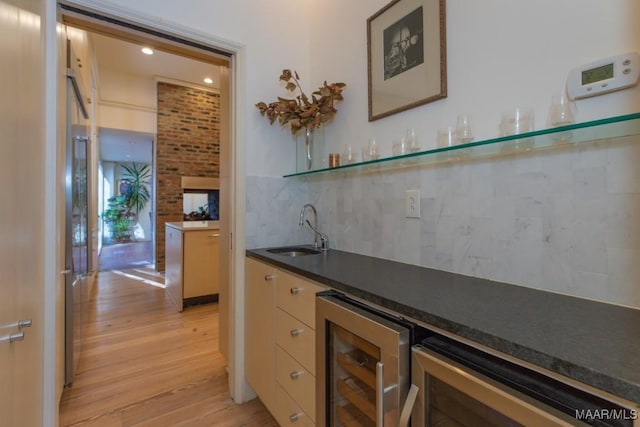 bar with tasteful backsplash, sink, wine cooler, and light hardwood / wood-style flooring