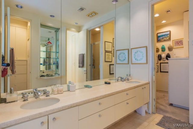 bathroom with vanity, a shower with shower door, and tile patterned floors