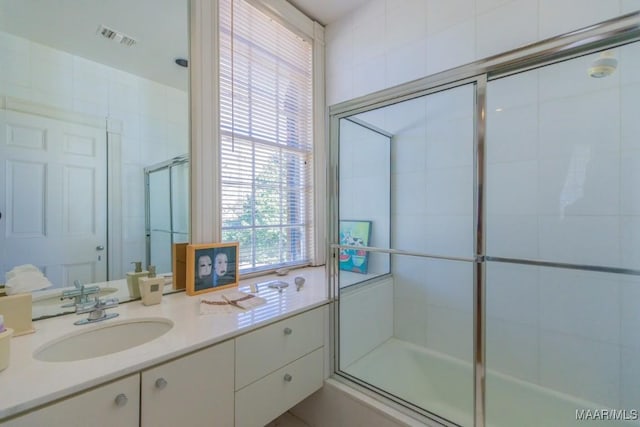 bathroom featuring vanity and bath / shower combo with glass door