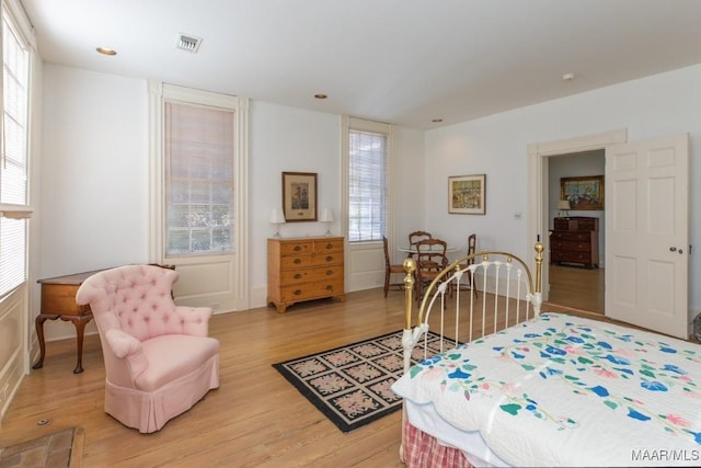 bedroom with light hardwood / wood-style floors and multiple windows