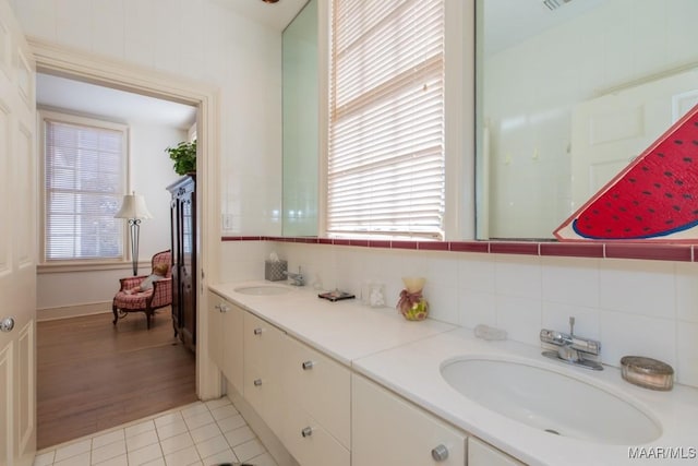 bathroom featuring tasteful backsplash, tile patterned floors, a healthy amount of sunlight, and vanity