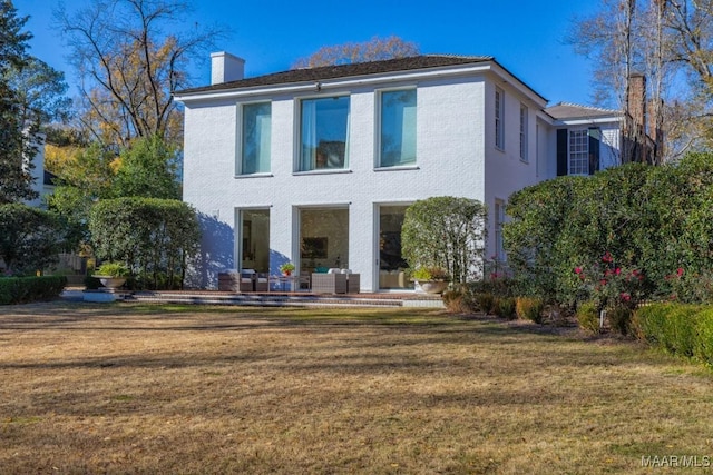 back of property featuring a yard and an outdoor hangout area